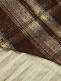 Detail of the plaid asymmetric pleated mini skirt