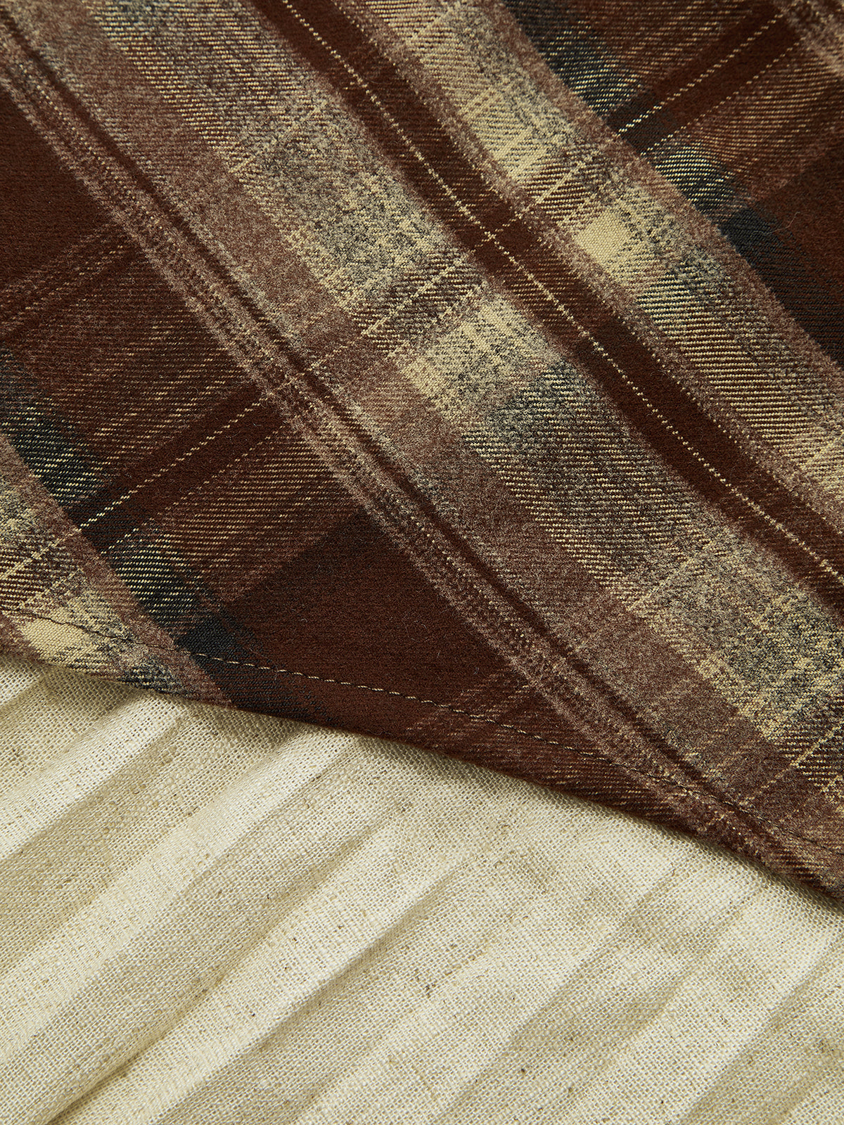 Detail of the plaid asymmetric pleated mini skirt