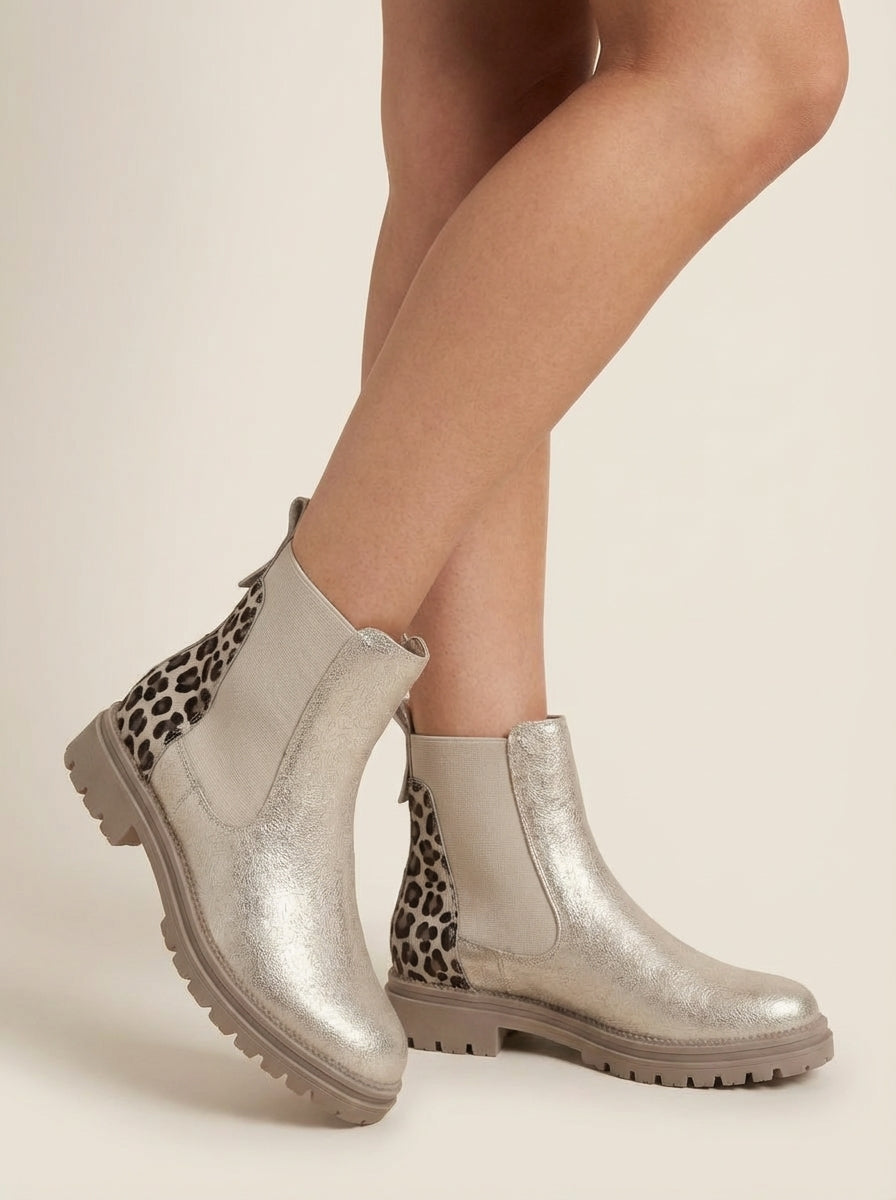 Woman wearing the brynn | gold chelsea boots with leopard heel