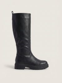 Woman wearing the anetta | black knee-high lug-sole boots